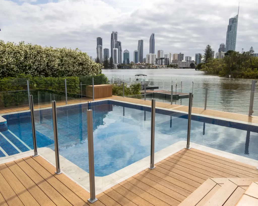 Luxury pool deck with composite timber and glass fencing overlooking Gold Coast waterways and Surfers Paradise skyline