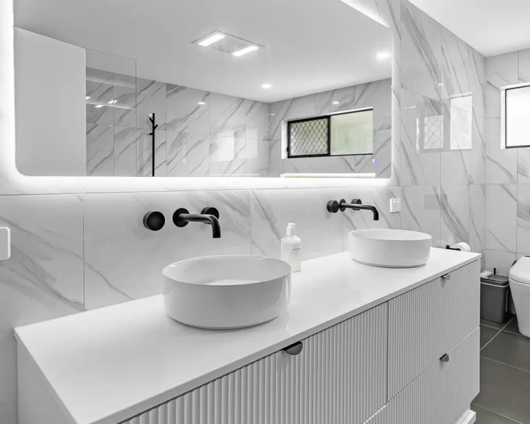 Modern Gold Coast bathroom renovation with double vanity, marble-look tiles, and matte black fixtures by Steedbuilt