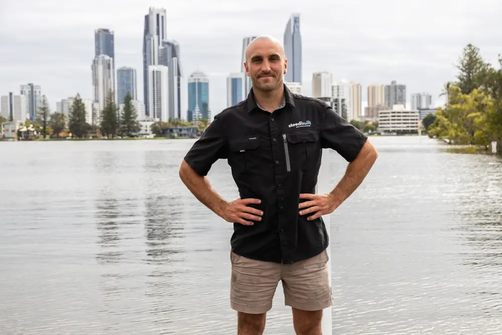 Steedbuilt builder on the Gold Coast waterfront with Surfers Paradise skyline, representing trusted local construction