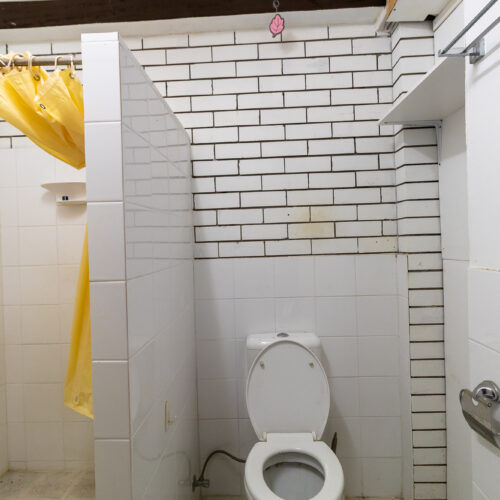 Dated bathroom before renovation at 14 Sunshine Boulevard, Broadbeach Waters - old white tiles and fixtures