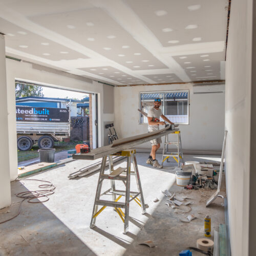 Steedbuilt team working on living room renovation at 14 Sunshine Boulevard, Broadbeach Waters - construction in progress with Steedbuilt trailer visible