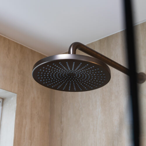 Black rainfall showerhead detail in bathroom renovation at 14 Sunshine Boulevard by Steedbuilt