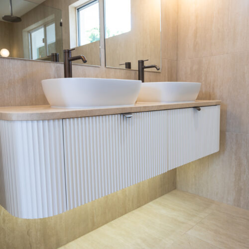 Custom bathroom vanity with textured cabinetry and double vessel basins at 14 Sunshine Boulevard by Steedbuilt