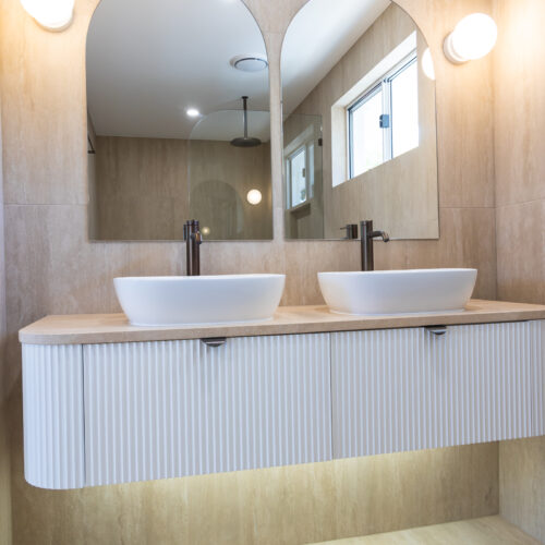 Modern bathroom with arched mirrors and double vanity at 14 Sunshine Boulevard, Broadbeach Waters by Steedbuilt