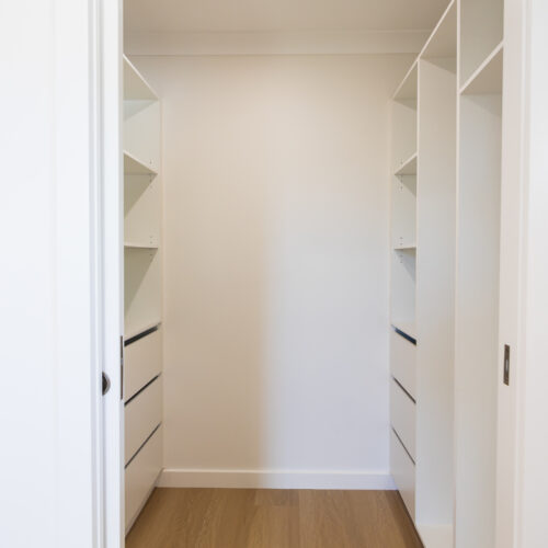 Custom walk-in wardrobe with built-in shelving and drawers at 14 Sunshine Boulevard by Steedbuilt