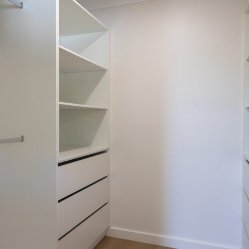Walk-in wardrobe with built-in drawers and shelving at 14 Sunshine Boulevard, Broadbeach Waters - Steedbuilt