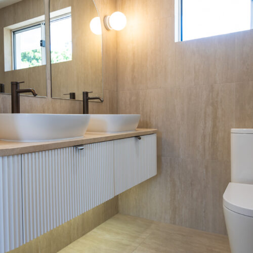 Modern bathroom vanity with double basins and custom cabinetry at 14 Sunshine Boulevard, Broadbeach Waters by Steedbuilt