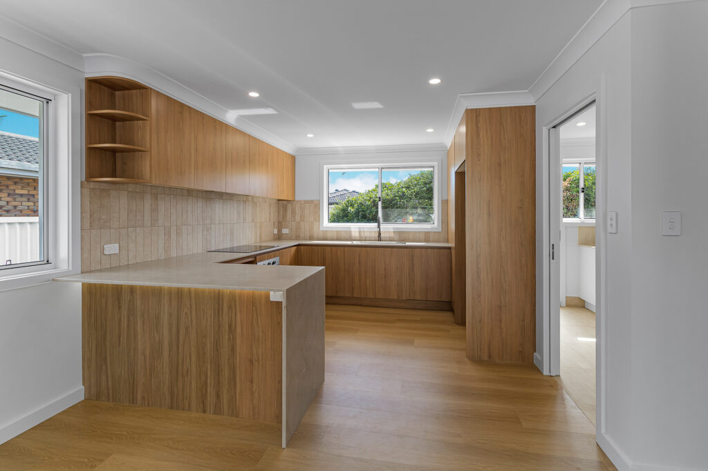 Modern white kitchen after renovation at 14 Sunshine Boulevard, Broadbeach Waters by Steedbuilt - stone benchtops and engineered flooring